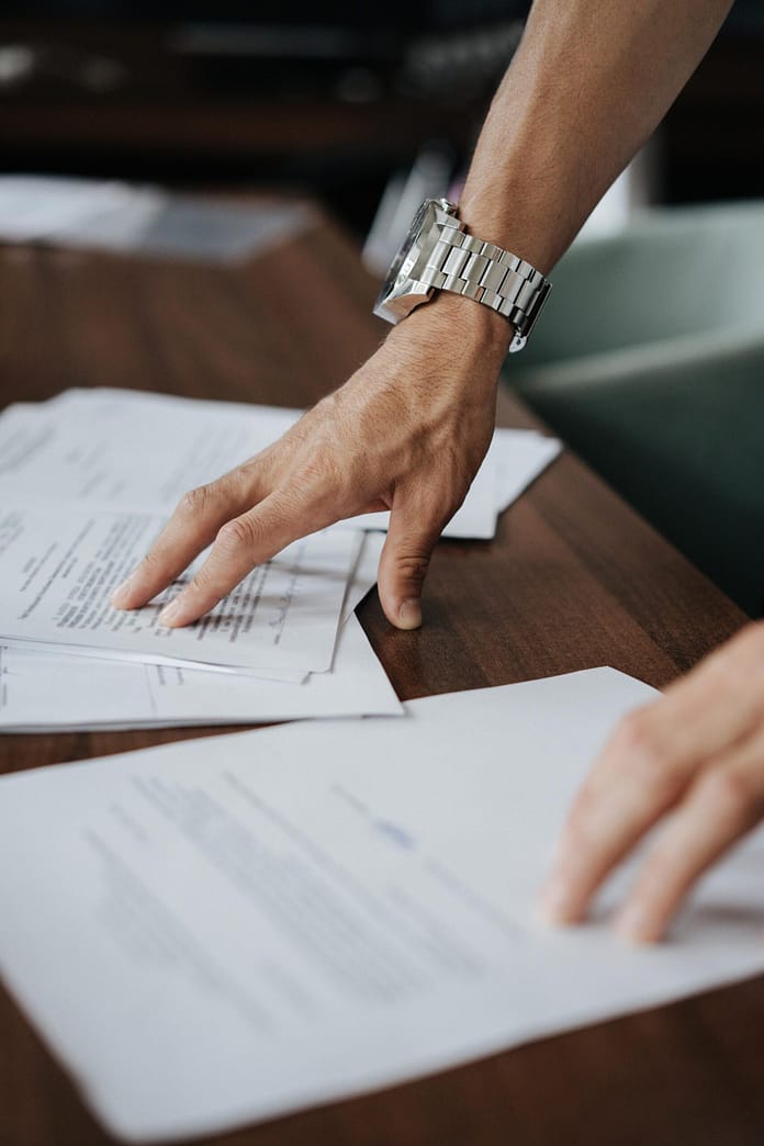 close-up of hands and papers on the table
