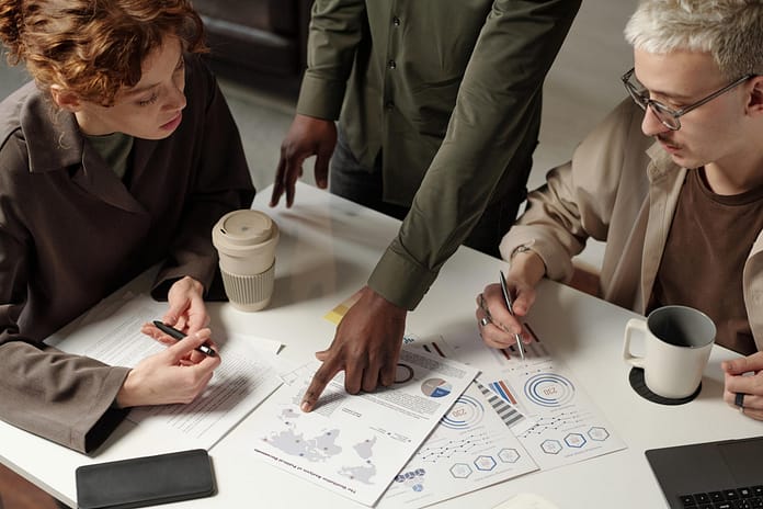 Three Specialists Working With Charts And Graphs